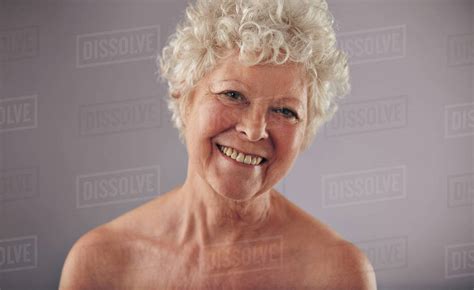 headshot of a beautiful mature woman isolated on grey background shirtless caucasian old female