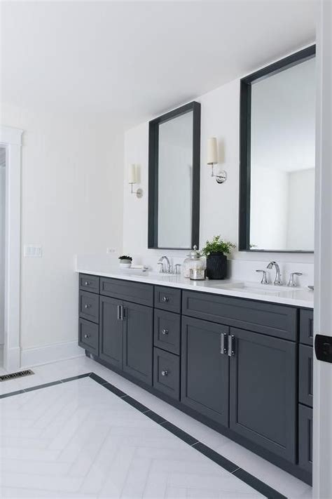 Large wall tile gives the illusion that rooms are larger than they actually are. Ziyi Sconces flank black box framed vanity mirrors over ...