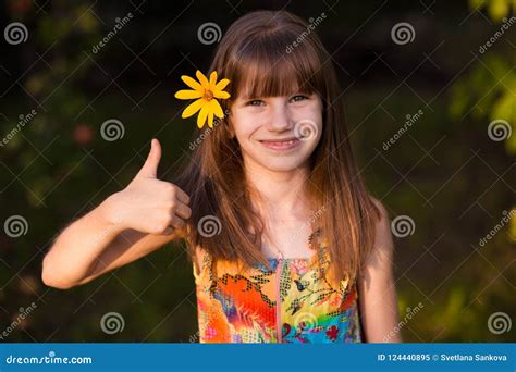 Portrait Of Adorable Girl With Flower Showing Thumbs Up Stock Image