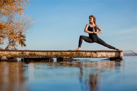 Mujer Joven Practicando Ejercicio De Yoga En El Tranquilo Muelle De Madera Con Fondo De Ciudad