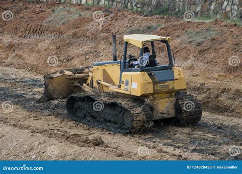 Yellow Bulldozer Scooping Dirt At A Construction Site Editorial Stock