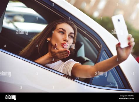 Young Woman In The Car Going On Holiday As A Passenger Makes Selfie