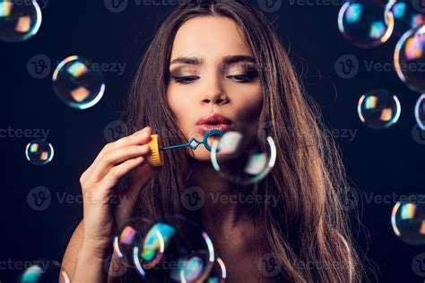 Bubble Fun Beautiful Young Woman Blowing Bubbles While Standing Against Black Background