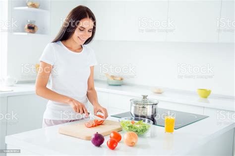 Adorable Attractive Young Brunette Smiling Woman Wearing Pajama Cutting Vegetables Cooking In
