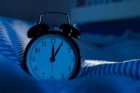 Premium Photo Alarm Clock On Bed In Dark Bedroom At Night Time