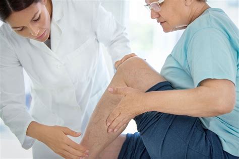 Closeup Side View Of Female Doctor Massaging Legs And Calves Of A