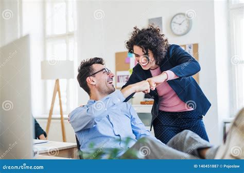 Two Young Cheerful Businesspeople In A Modern Office Making Fist Bump Stock Image Image Of