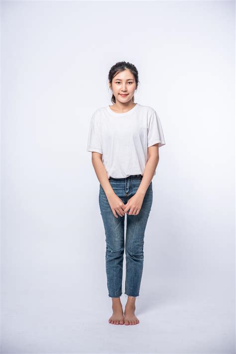 Girl In White Stretch Jeans And Standing Straight On White Background Stock Photo At