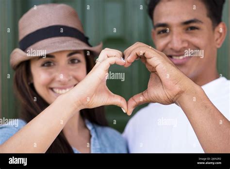 portrait of happy couple making heart shape sign with hands happy adult couple falling in love