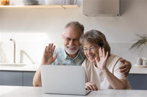 Happy Senior Couple Talking To Children On Video Call Stock Image