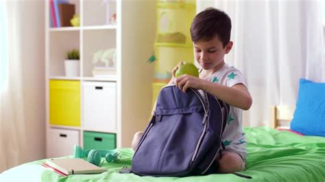 Boy Packing Schoolbag With School Supplies At Home 12 Stock Footage