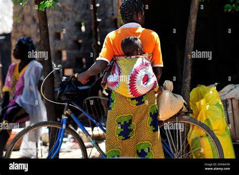 A Burkinabe Woman Carrying Her Baby On Her Back At A Local Market In