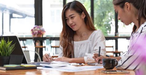 Two Young Beautiful Asian Business Woman In The Conversation