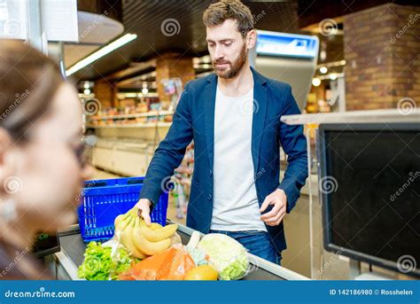 Man With Woman Cashier At The Cash Register In The Supermarket Stock