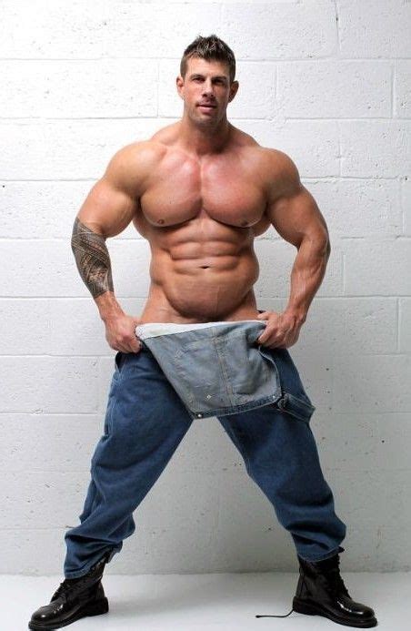 A Shirtless Man Is Posing With His Pants Open And Showing Off His
