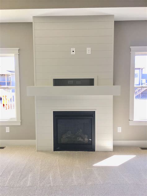 Wood plank wall with narrow mantle, long narrow fire box raised from floor. Shiplap fireplace! #Livingroomideas | Farmhouse fireplace ...