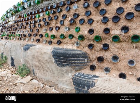 Glass Bottles And Used Tires Used In Construction Of Earthship Wall