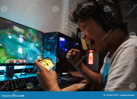 Asian Gamer Boy Screaming While Playing Video Games On Smartphone And