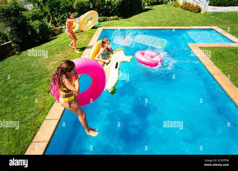 gruppe kleine kinder in der luft springen in das schwimmen pool mit aufblasbaren spielzeugen