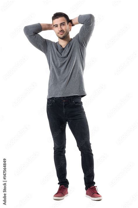 Handsome Smiling Fashion Model Posing With Hands Behind Head Full Body