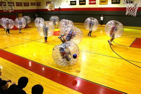 Some People Are Playing With Inflatable Balls On A Basketball Court