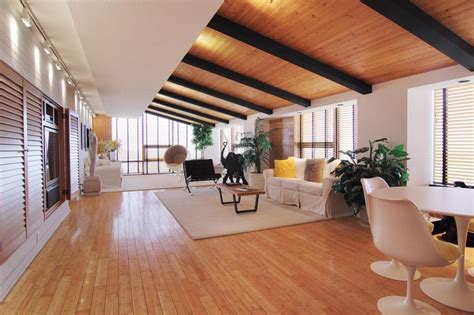 Wood walls have a long history. Living area with bamboo flooring and slanted wood ceiling ...