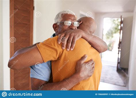 Loving Senior Father Hugging Adult Son Indoors At Home Stock Image