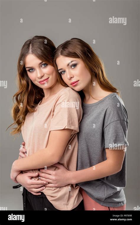 Portrait Of Beautiful Twin Sisters Hugging Each Other And Looking At