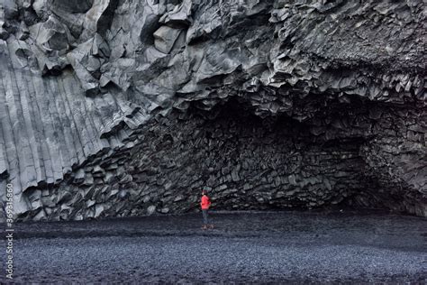 Iceland Tourist Woman Walking On Reynisfjara Black Sand Beach By Basalt