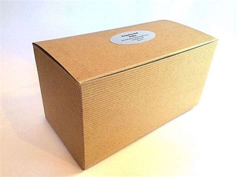 An Open Cardboard Box With A White Label On The Top And Bottom Sitting On A Plain Surface