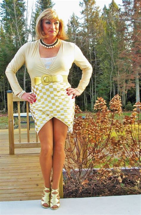 a woman standing on a wooden deck wearing a skirt and heels with her hands on her hips
