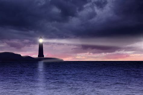 Lighthouse And Seascape With Dark Clouds At Night Stock Photo