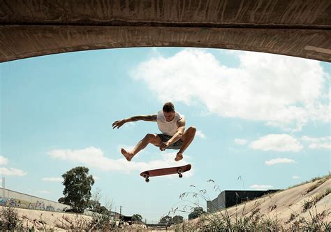 Skateboarder In Mid Air During A Kickflip By Colin Anderson Authentic