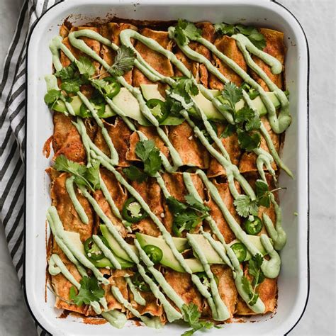 A serving of casserole layered between corn tortillas on a white plate. 27 Incredible Vegan Dinner Recipes to Put on Your Menu ...