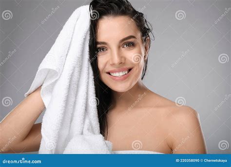 Happy Young Woman Drying Hair With Towel After Washing On Light Grey
