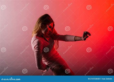 Slender Female On A Coloured Background Of Neon Color Posing In A