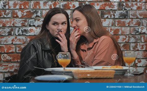 Young And Cheerful Girls Gossip And Whisper To Each Other While Sitting In A Cafe Stock Footage