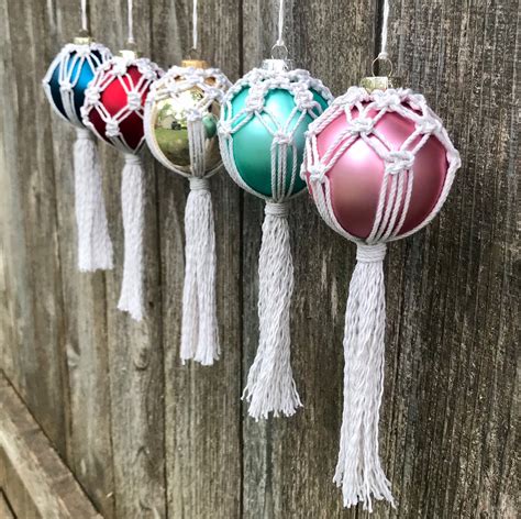 Four Ornaments Hanging From A Wooden Fence