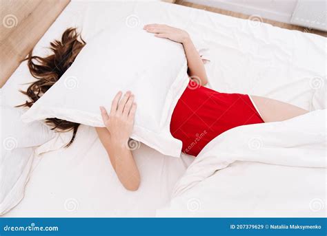 the girl in the morning after waking up in bed in an embrace with a pillow does not want to get
