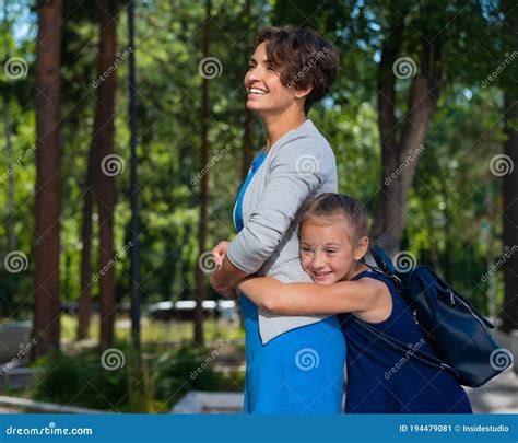 Excited Schoolgirl Hugs Mom Behind Her Back The Girl Missed Her Mother