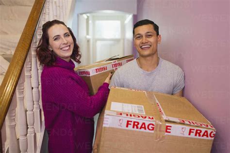 Portrait Happy Couple Moving House Carrying Cardboard Boxes In