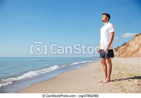 Man Standing And Relaxing On The Beach Handsome Young Man Standing And