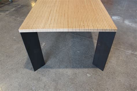This has a nicer looking veneer and this is pretty straightforward, but we have to make sure the first layer is square. plywood table with steel base