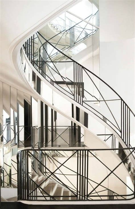 A Spiral Staircase In An Office Building With Glass Railings And Steel