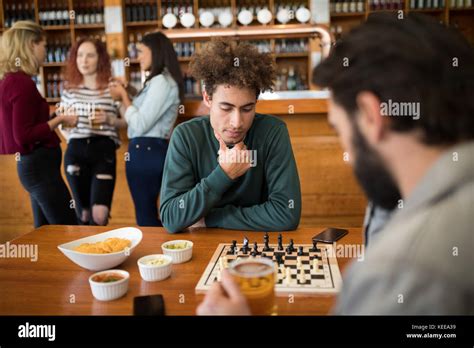 Two Men Playing Chess While Having Glass Of Beer In Bar Stock Photo Alamy