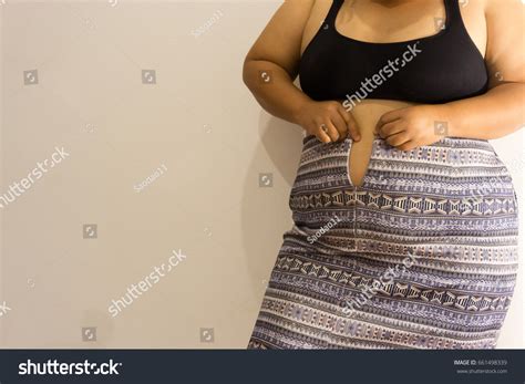 Overweight Woman Trying Fasten Her Skirt Shutterstock