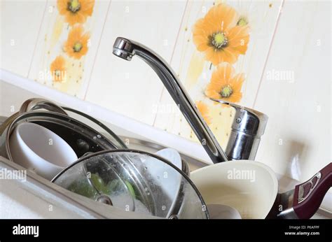 Dirty Dishes And Unwashed Kitchen Appliances Filled The Kitchen Sink