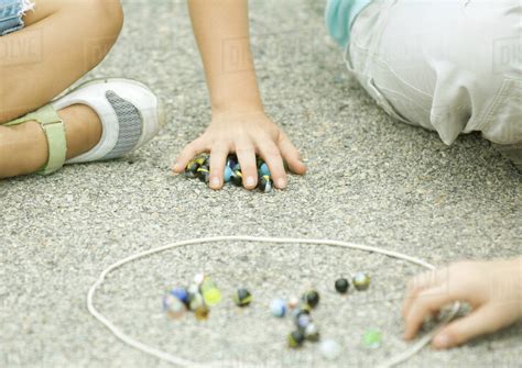 Children Playing Marbles On Asphalt Stock Photo Dissolve