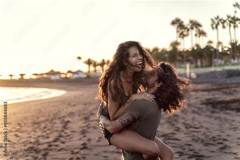 happy beautfiul italian couple having fun together on the beach laughing sunset time stock