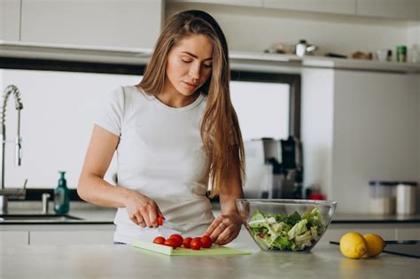 Free Photo Young Woman Making Salad At The Kitchen